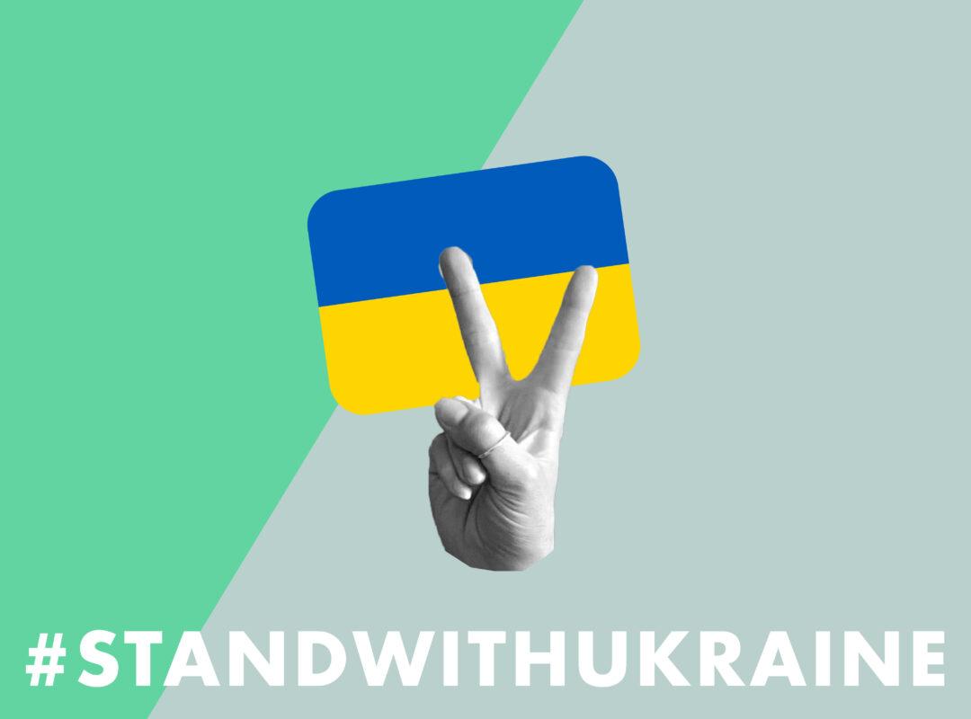 Eine ukrainische Flagge mit einer Hand die Peace zeigt