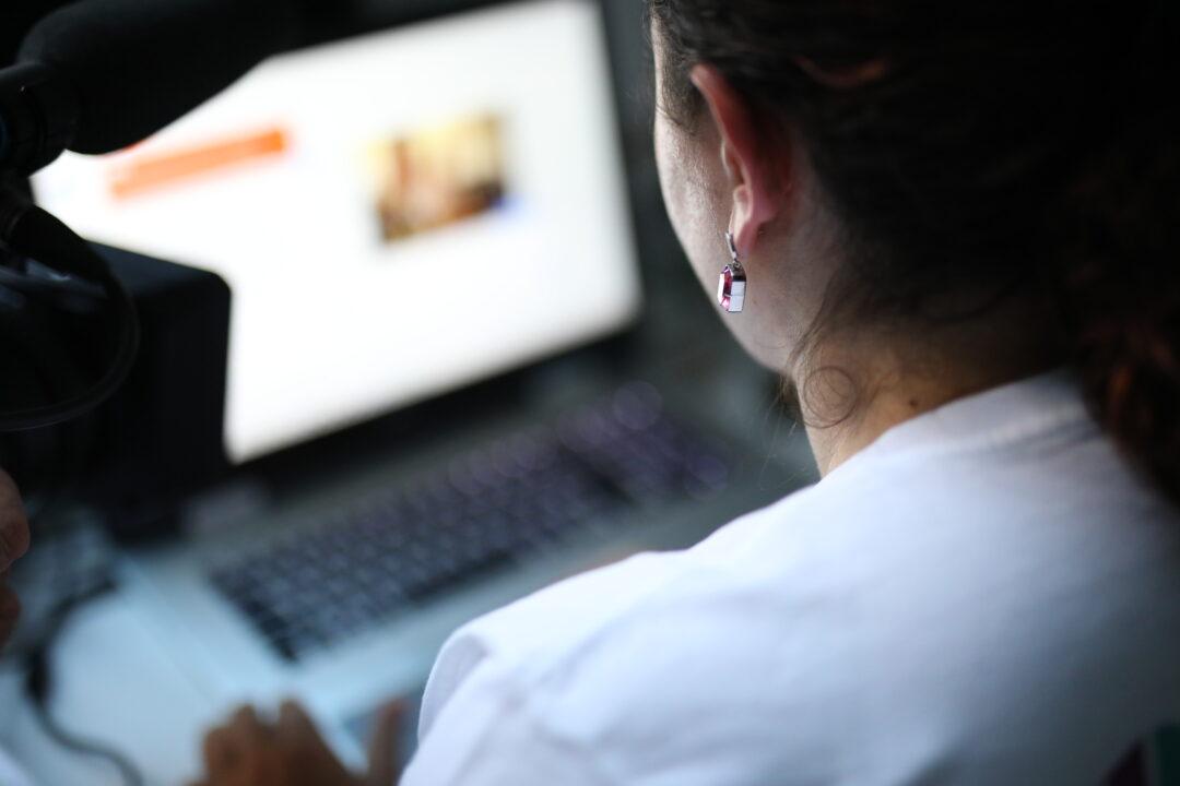 Eine Junge Frau sitzt vor einem Laptop