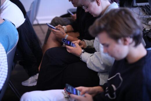 Junge Menschen blicken auf ihr Handy