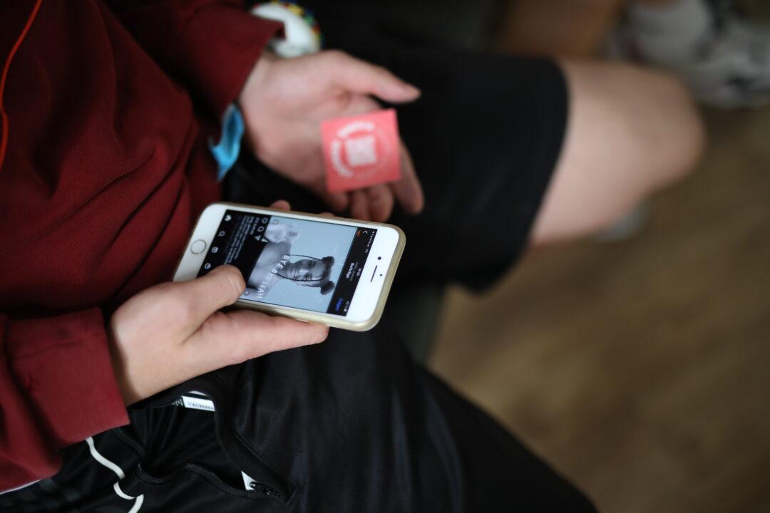 Eine Person hät ein Handy in der Hand.